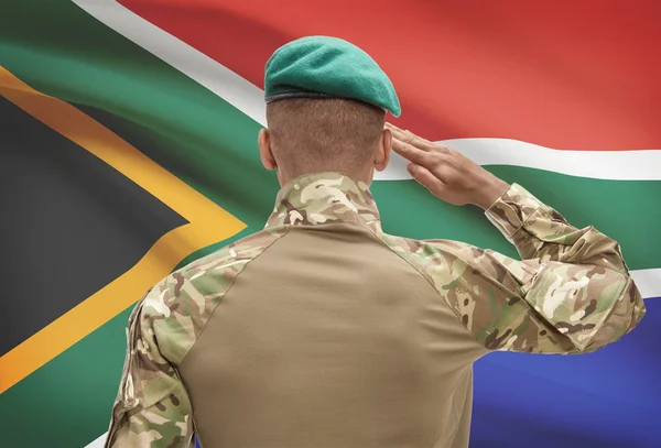 Dark-skinned soldier with flag on background - South Africa — Stock Photo, Image