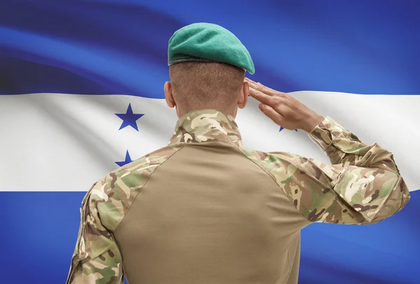 Dark-skinned soldier with flag on background - Honduras — Stock Photo, Image