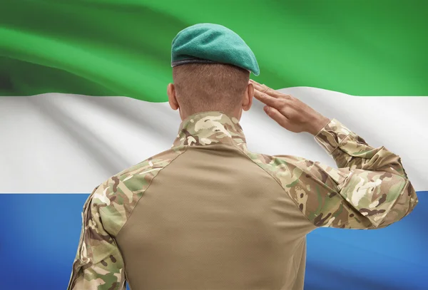 Donkerhuidige soldaat met vlag op achtergrond - Sierra Leone — Stockfoto