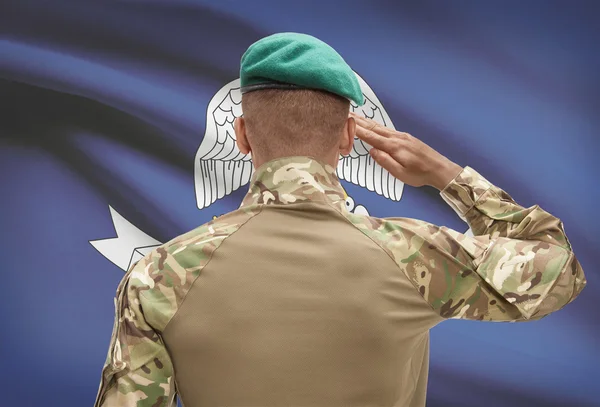 Dark-skinned soldier with US state flag on background - Louisiana — Stock Photo, Image