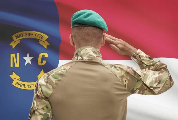 Soldado de piel oscura con nosotros estado de bandera en el fondo - Carolina del norte — Foto de Stock