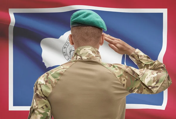 黝黑的士兵，与我们国家国旗背景-怀俄明州 — 图库照片