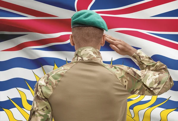 Dark-skinned soldier with Canadian province flag on background - British Columbia — Stock Photo, Image