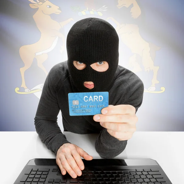 Hacker holding credit card with US state flag - Michigan — Stock Photo, Image