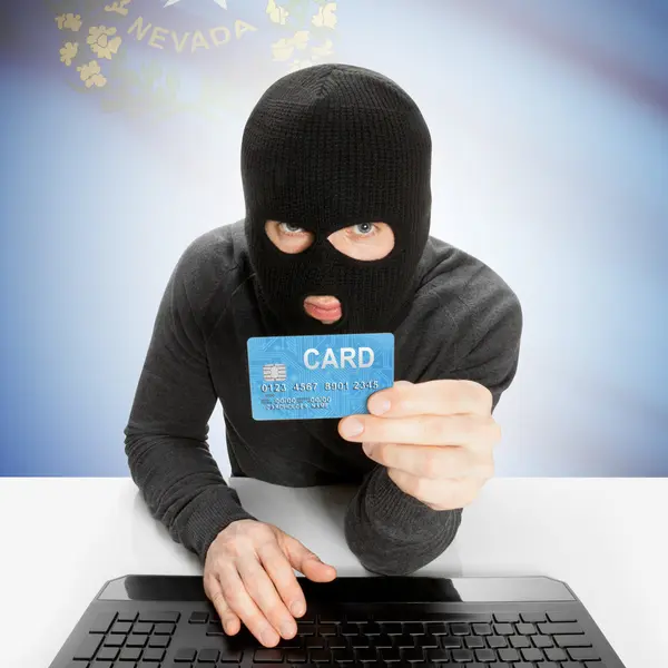 Hacker holding credit card with US state flag - Nevada — Stock Photo, Image