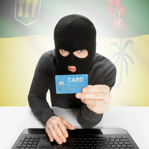 Hacker com cartão de crédito na mão e a bandeira da província de Canadá - Saskatchewan — Fotografia de Stock