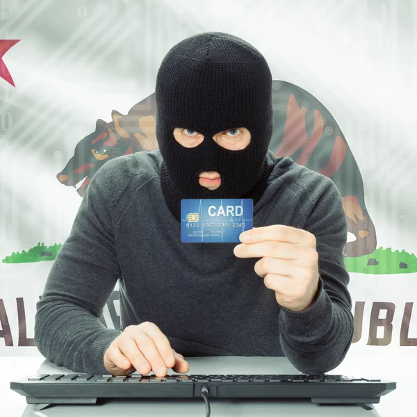 Hacker holding credit card and USA state flag - California — Stock Photo, Image