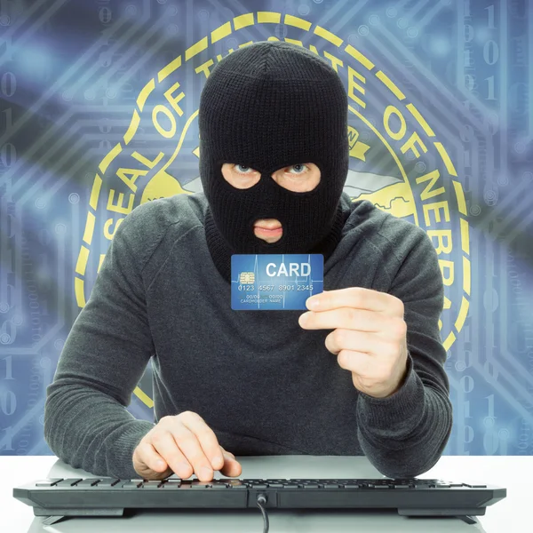 Hacker holding credit card and USA state flag - Nebraska — Stock Photo, Image