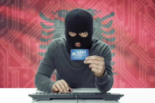 Koyu tenli hacker ile kredi kartı - Arnavutluk holding arka plan bayrak — Stok fotoğraf