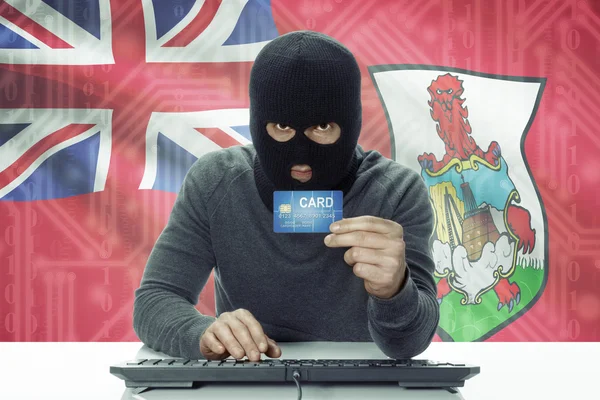 Hacker de piel oscura con bandera sobre fondo con tarjeta de crédito - Bermudas —  Fotos de Stock