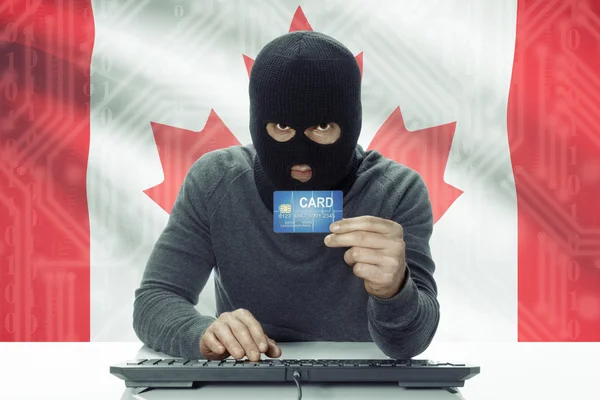 Темнокожих хакер с флагом на фоне проведения кредитной карты - Канада — стоковое фото
