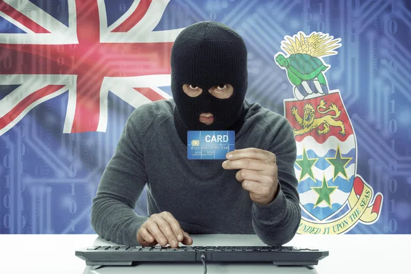 Hacker de piel oscura con bandera sobre fondo con tarjeta de crédito - Islas Caimán —  Fotos de Stock