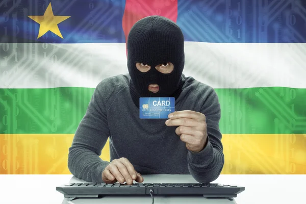 Dark-skinned hacker with flag on background holding credit card - Central African Republic — Stock Photo, Image