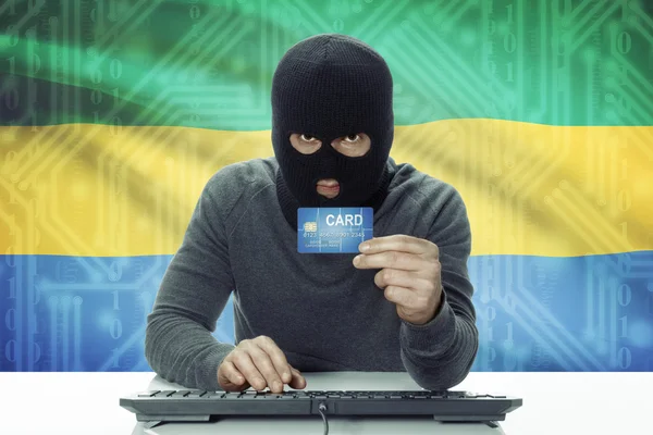 皮肤黑黑客与持有信用卡-加蓬的背景上的标志 — 图库照片