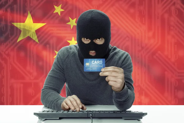 Dunkelhäutige Hacker mit Flagge auf Hintergrund halten Kreditkarte - China — Stockfoto
