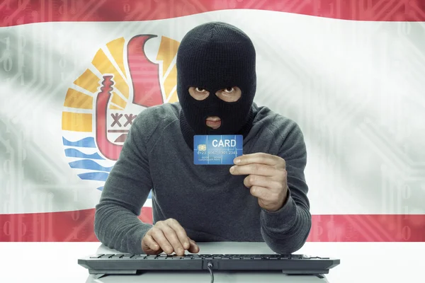 Dark-skinned hacker with flag on background holding credit card - French Polynesia — Foto de Stock