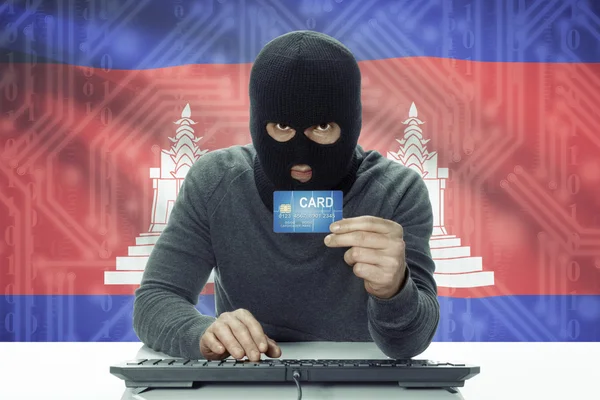 Dark-skinned hacker with flag on background holding credit card - Cambodia — 图库照片