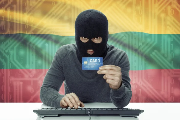 Dark-skinned hacker with flag on background holding credit card - Lithuania — 图库照片