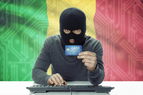 Dunkelhäutige Hacker mit Flagge auf Hintergrund hält Kreditkarte - Mali — Stockfoto