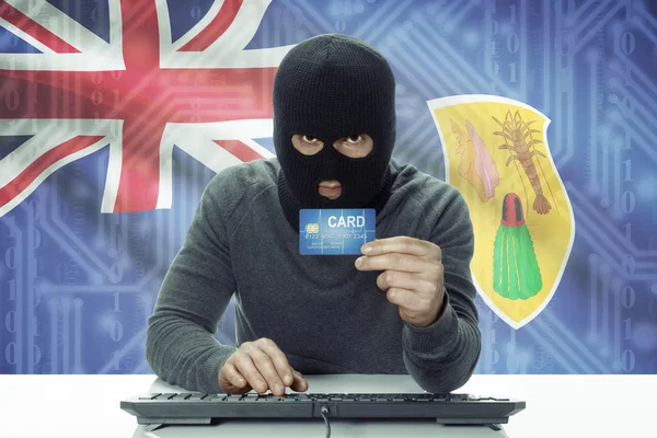 Dark-skinned hacker with flag on background holding credit card - Turks and Caicos Islands —  Fotos de Stock