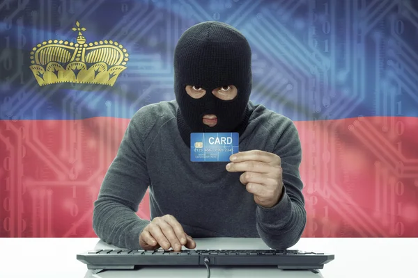 Dark-skinned hacker with flag on background holding credit card - Liechtenstein — Stock Photo, Image