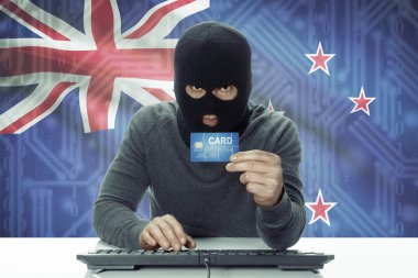 Dark-skinned hacker with flag on background holding credit card - New Zealand