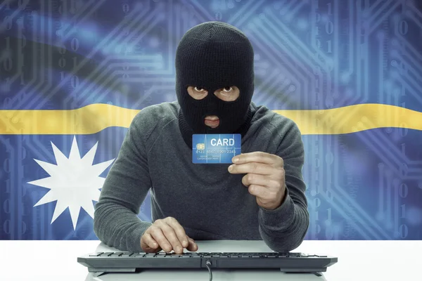 Dark-skinned hacker with flag on background holding credit card - Nauru — 图库照片