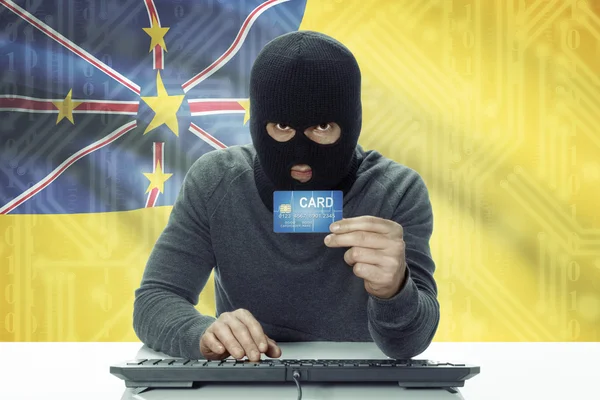 Dark-skinned hacker with flag on background holding credit card - Niue — Foto de Stock