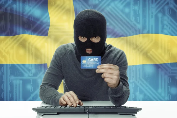 Dark-skinned hacker with flag on background holding credit card - Sweden — 图库照片