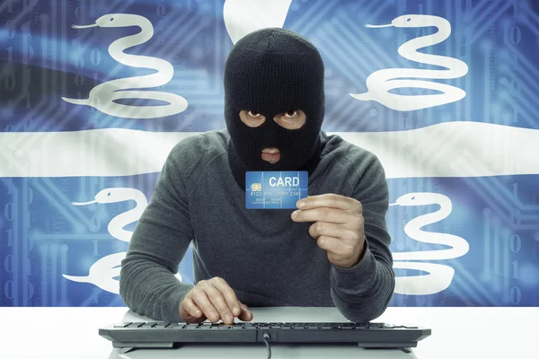 Dark-skinned hacker with flag on background holding credit card - Martinique — 图库照片