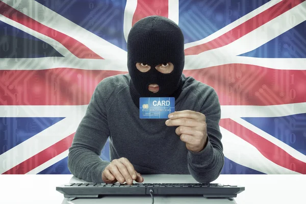 Темнокожая хакер с флагом на фоне проведения кредитной карты - Великобритания — стоковое фото