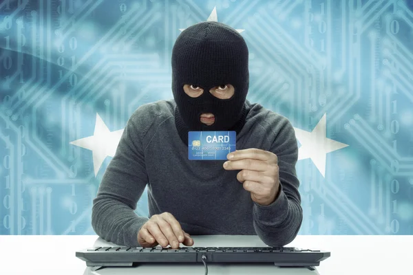 Dark-skinned hacker with flag on background holding credit card - Micronesia — Stock fotografie