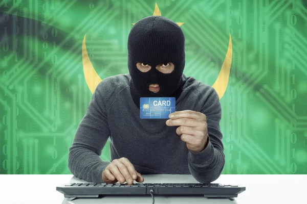 Dark-skinned hacker with flag on background holding credit card - Mauritania — 스톡 사진