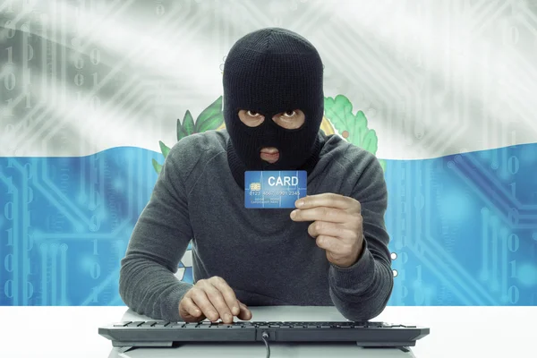 Dark-skinned hacker with flag on background holding credit card - San Marino — Foto Stock