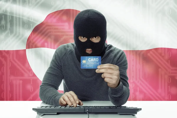 Dark-skinned hacker with flag on background holding credit card - Greenland — 图库照片