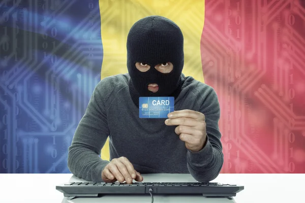 Dark-skinned hacker with flag on background holding credit card - Romania — 图库照片