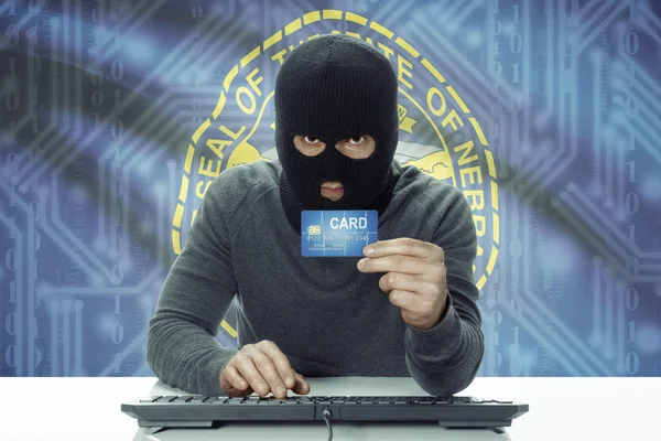 Dark-skinned hacker with USA states flag on background holding credit card - Nebraska —  Fotos de Stock