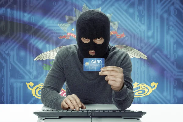 Dark-skinned hacker with USA states flag on background holding credit card - North Dakota —  Fotos de Stock