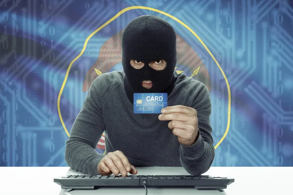 Dark-skinned hacker with USA states flag on background holding credit card - Utah — Stock fotografie