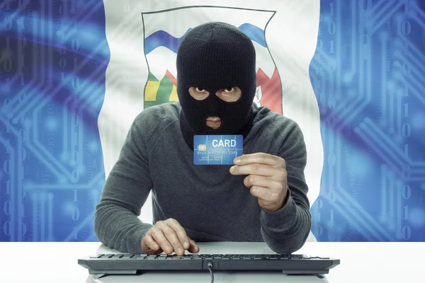 Dark-skinned hacker with Canadian province flag on background holding credit card - Northwest Territories — Stock fotografie