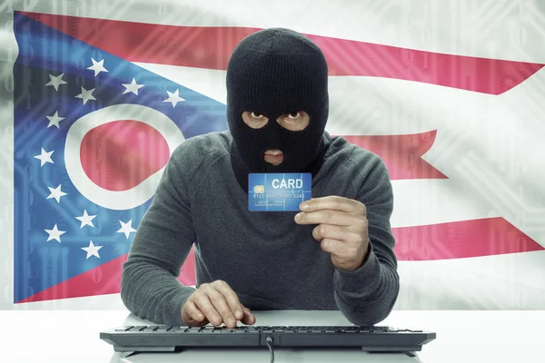 Dark-skinned hacker with USA states flag on background holding credit card - Ohio —  Fotos de Stock