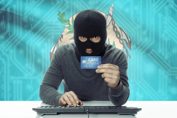 Dark-skinned hacker with USA states flag on background holding credit card - Oklahoma — Stock fotografie