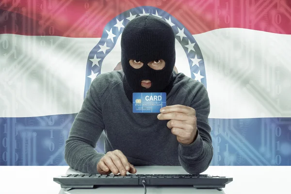 Dark-skinned hacker with USA states flag on background holding credit card - Missouri — Foto de Stock