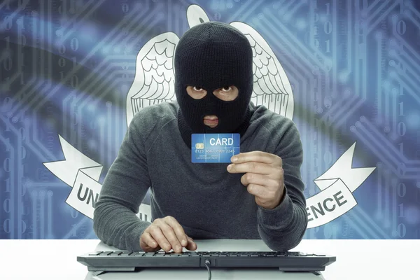 Dark-skinned hacker with USA states flag on background holding credit card - Louisiana — Stock fotografie