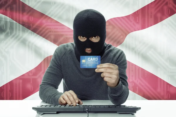 Dark-skinned hacker with USA states flag on background holding credit card - Alabama —  Fotos de Stock