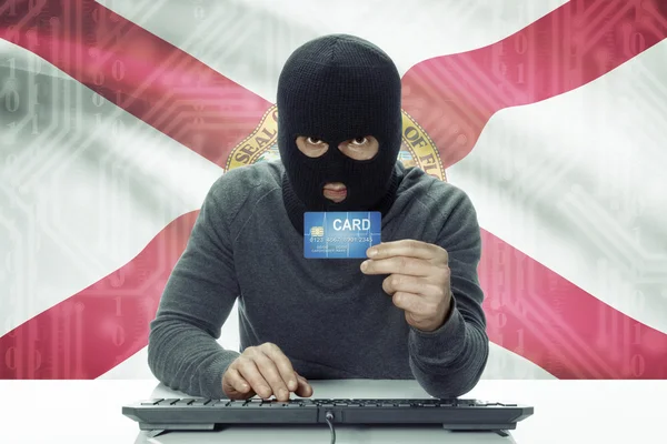 Hacker de piel oscura con los E.e.u.u. los Estados bandera sobre fondo con tarjeta de crédito - Florida —  Fotos de Stock