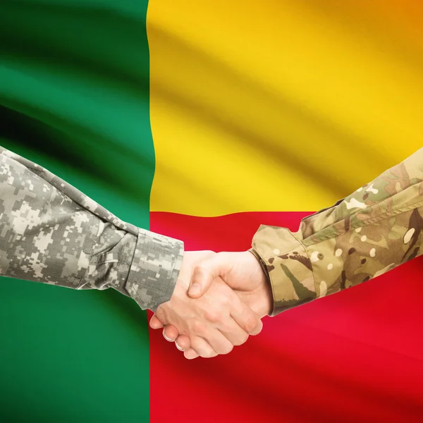 Men in uniform shaking hands with flag on background - Benin — Stock Photo, Image