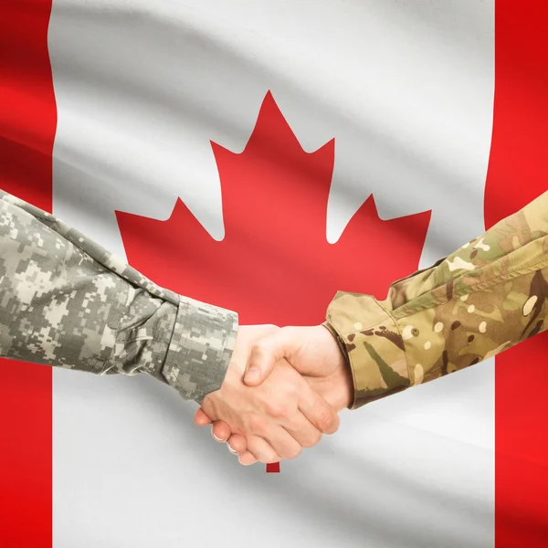 Men in uniform shaking hands with flag on background - Canada — Stock Photo, Image