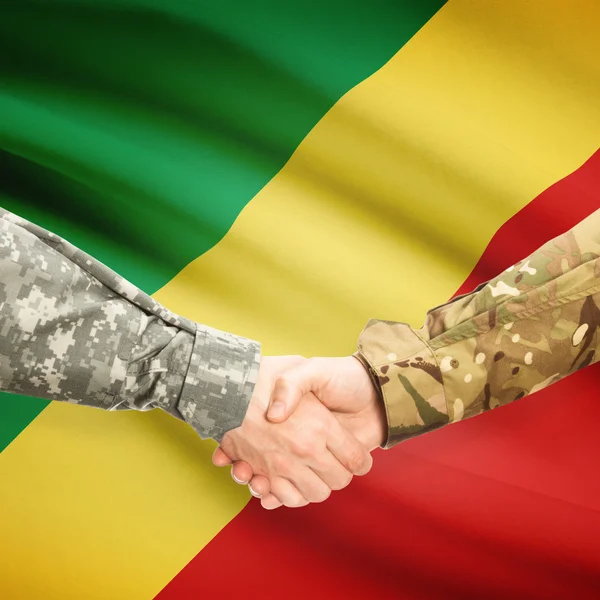 Hombres en uniforme de estrecharme la mano con la bandera en el fondo - Congo-Bra — Foto de Stock
