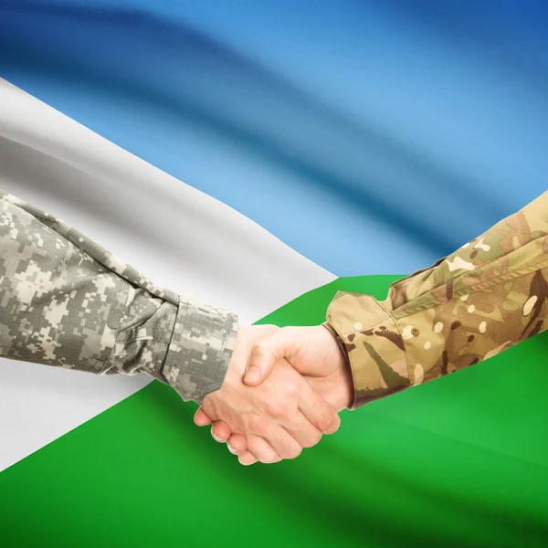 Hombres en uniforme de estrecharme la mano con la bandera en el fondo - Djibouti —  Fotos de Stock